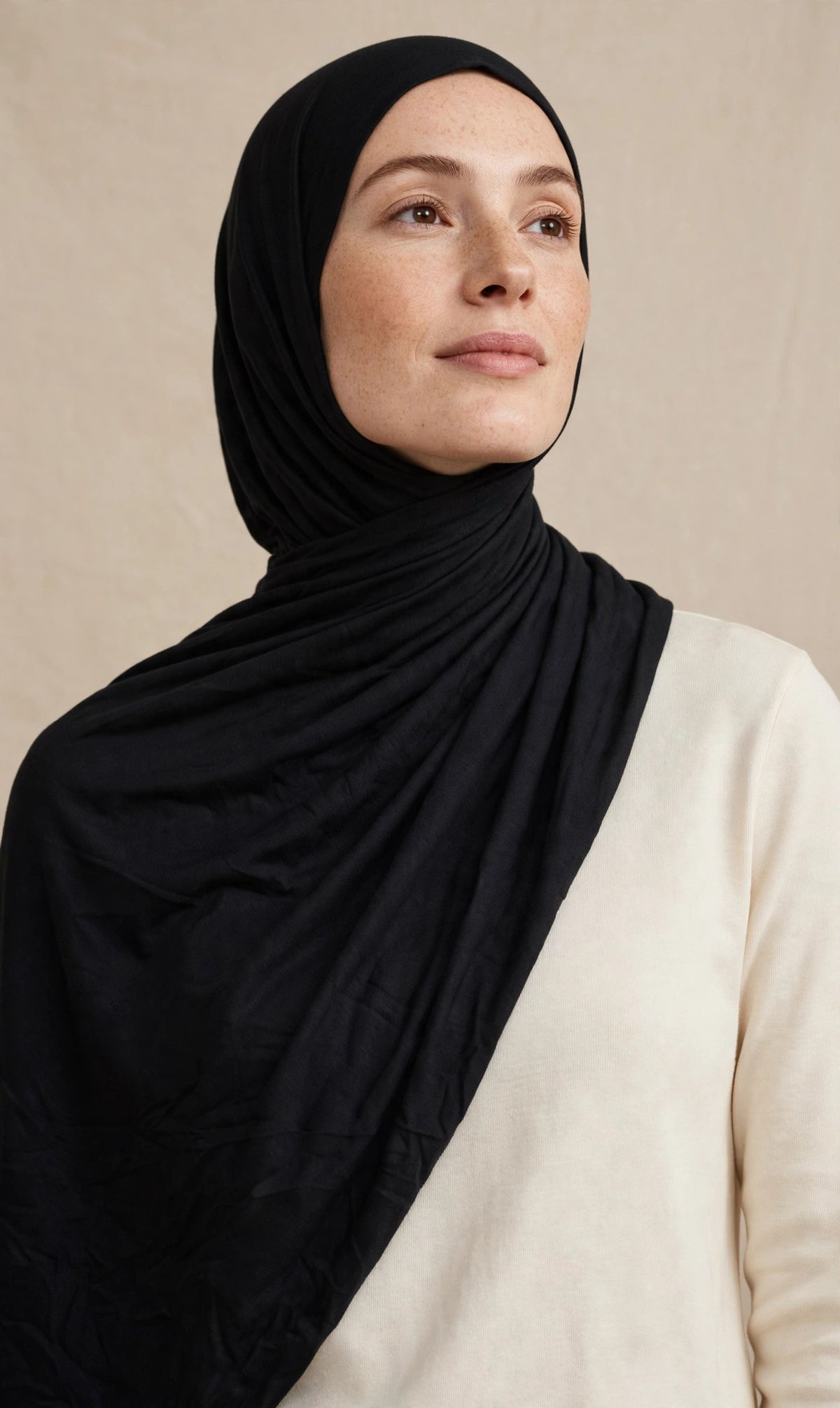 Model wearing the Black premium jersey hijab styled with a cream top - Concealed Muslimah