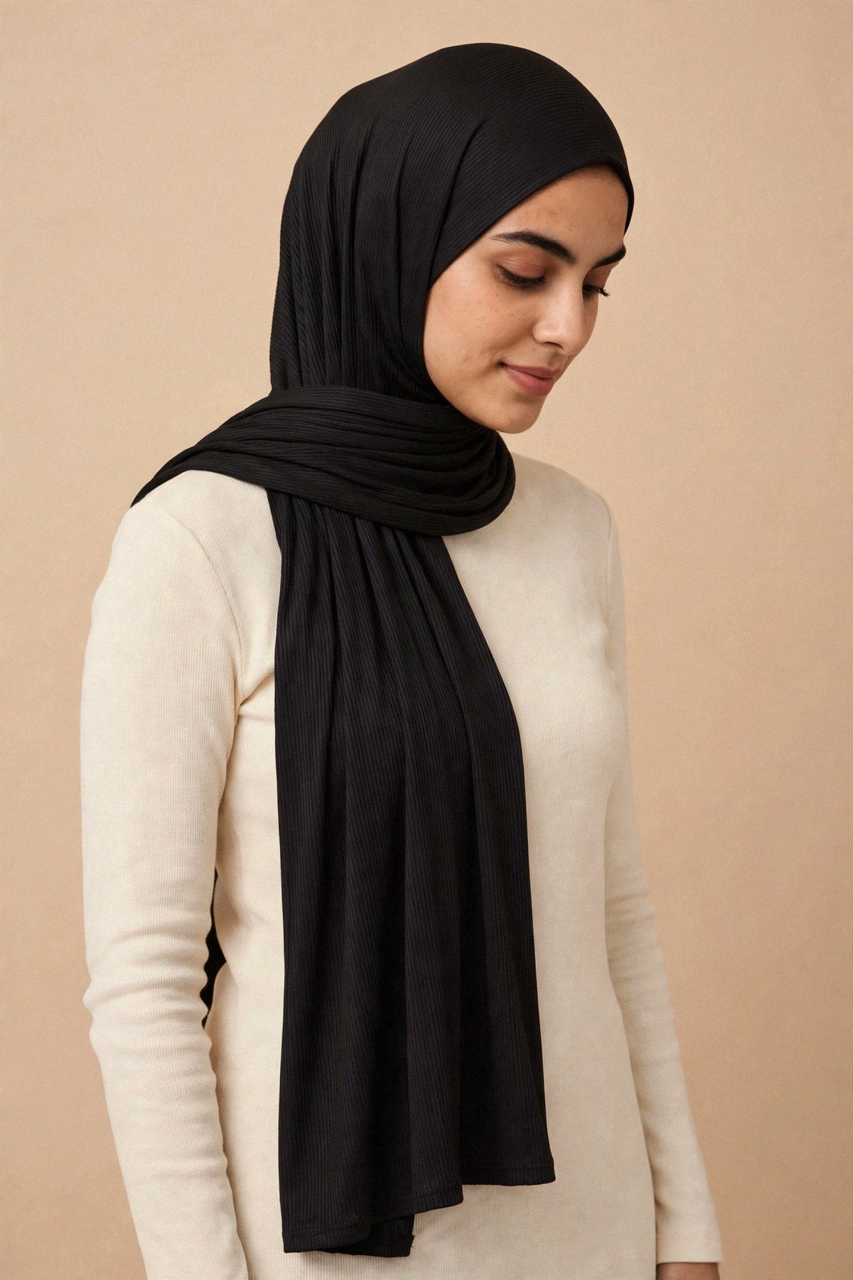 Model wearing the Black ribbed jersey hijab styled with a cream top - Concealed Muslimah