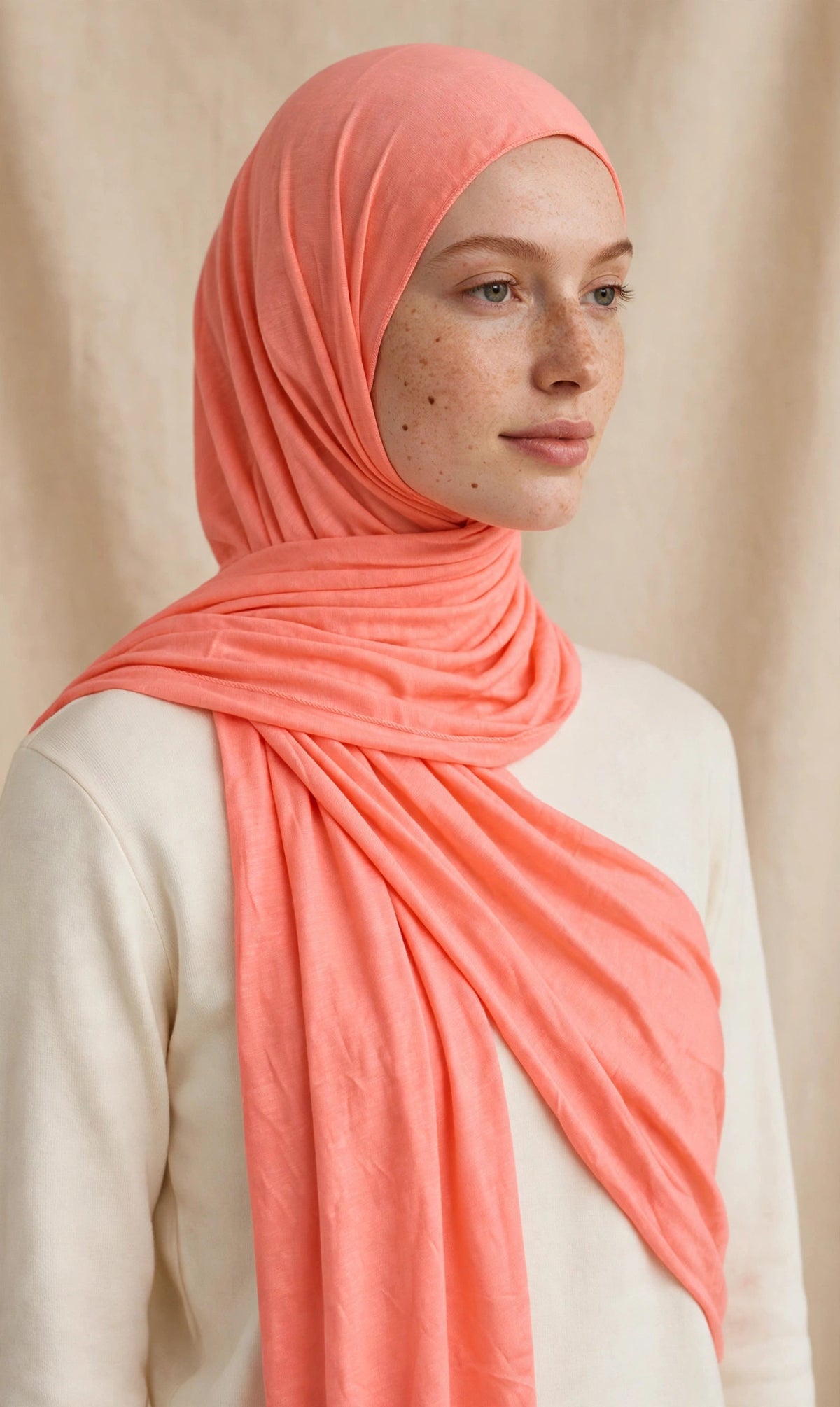 Model wearing the Bright Peach premium jersey hijab styled with a cream top - Concealed Muslimah