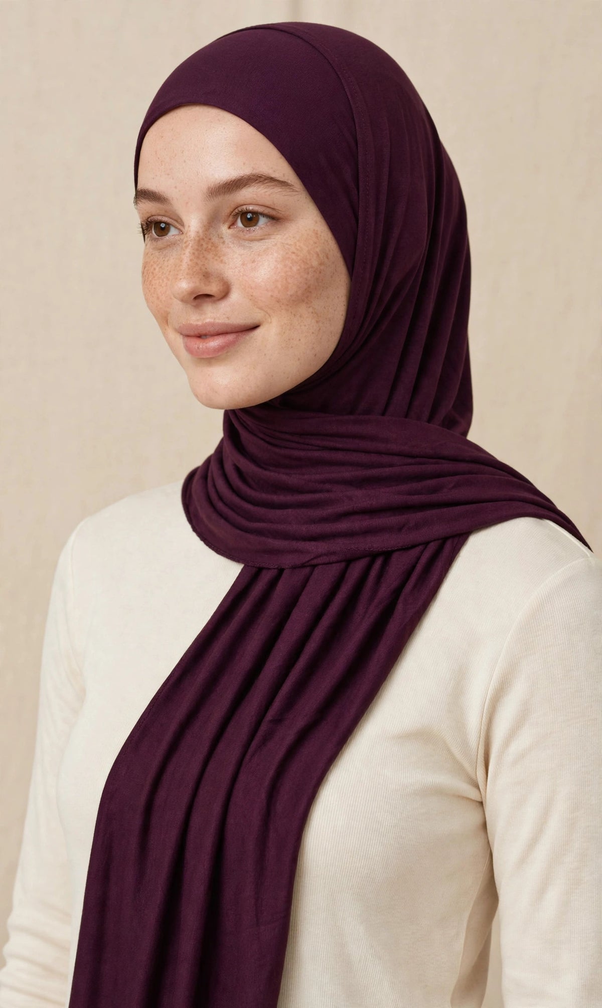 Model wearing the Brinjal premium jersey hijab styled with a cream top - Concealed Muslimah