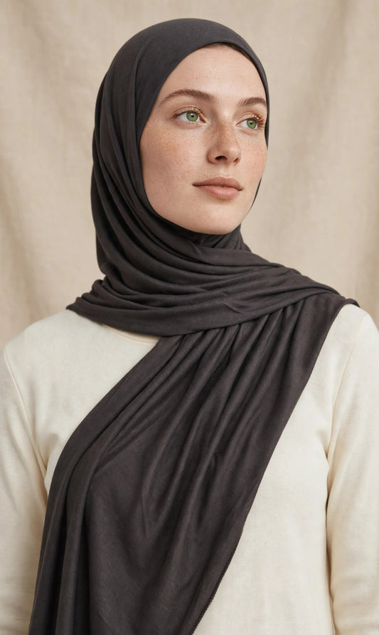 Model wearing the Charcoal premium jersey hijab styled with a cream top - Concealed Muslimah