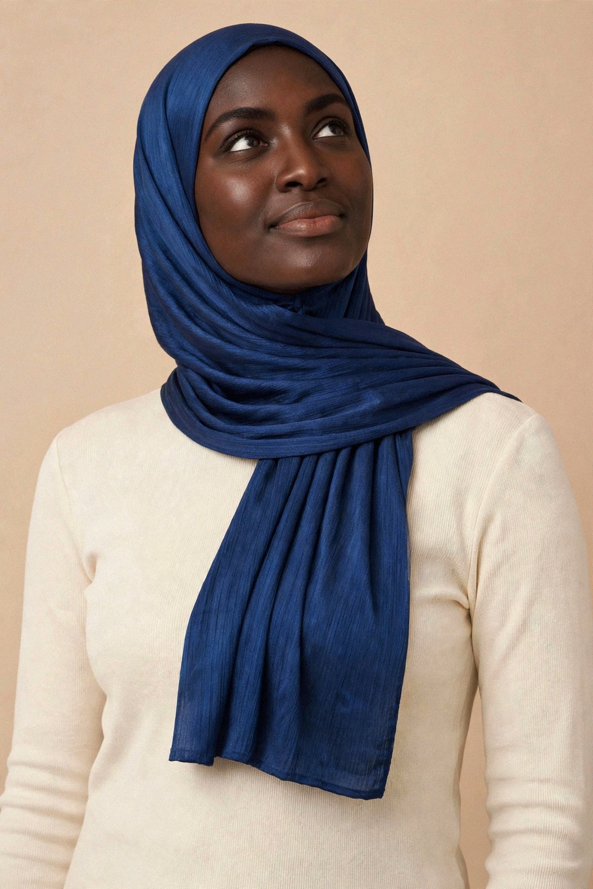 Model wearing the Ink Blue chrome hijab styled with a cream top - Concealed Muslimah