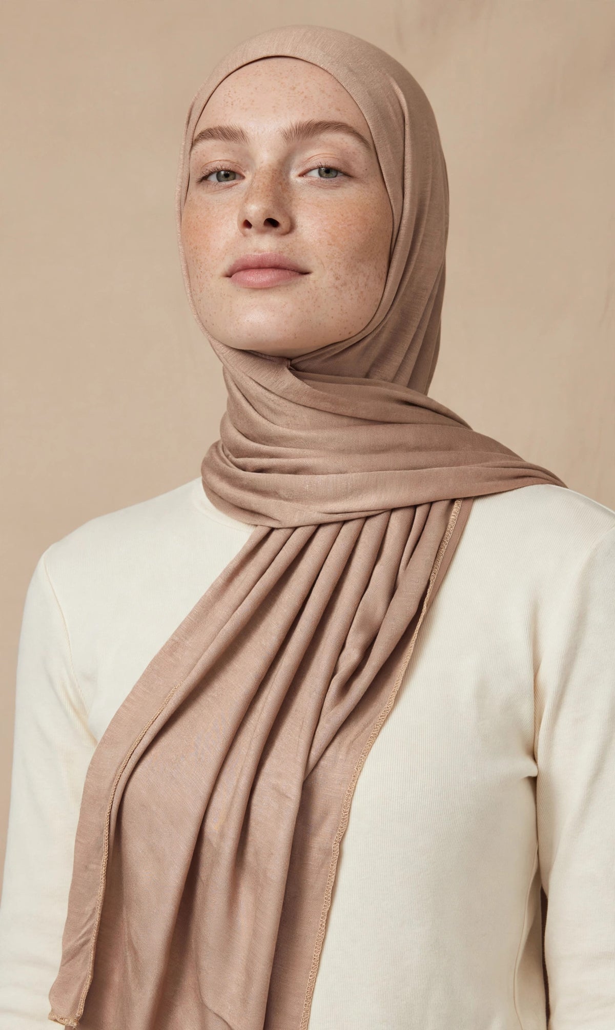 Model wearing the Latte premium jersey hijab styled with a cream top - Concealed Muslimah