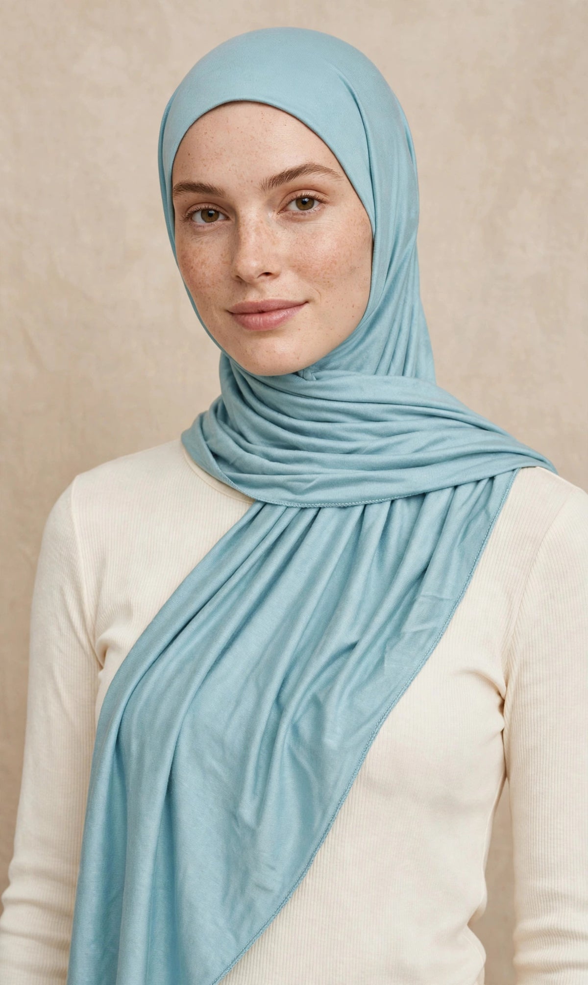 Model wearing the Mint Blue premium jersey hijab styled with a cream top - Concealed Muslimah
