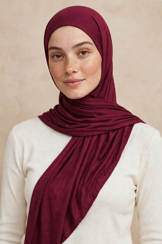 Model wearing the Mulberry Maroon premium jersey hijab styled with a cream top - Concealed Muslimah