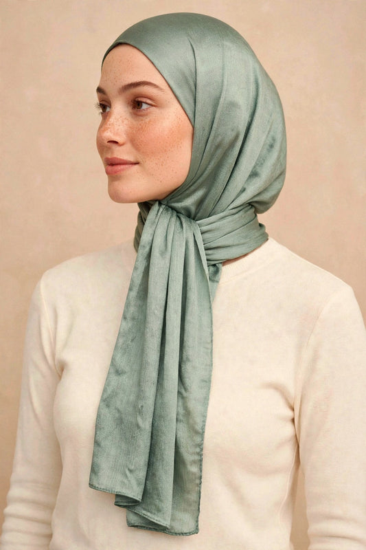 Model wearing the Olive chrome hijab styled with a cream top - Concealed Muslimah