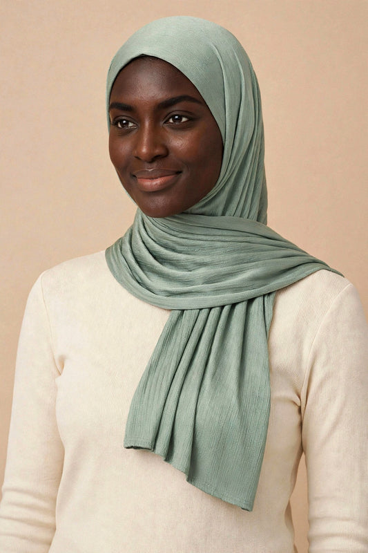 Model wearing the Olive chrome hijab styled with a cream top - Concealed Muslimah