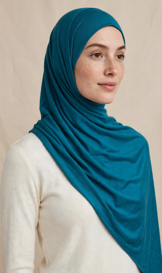 Model wearing the Peacock Teal premium jersey hijab styled with a cream top - Concealed Muslimah