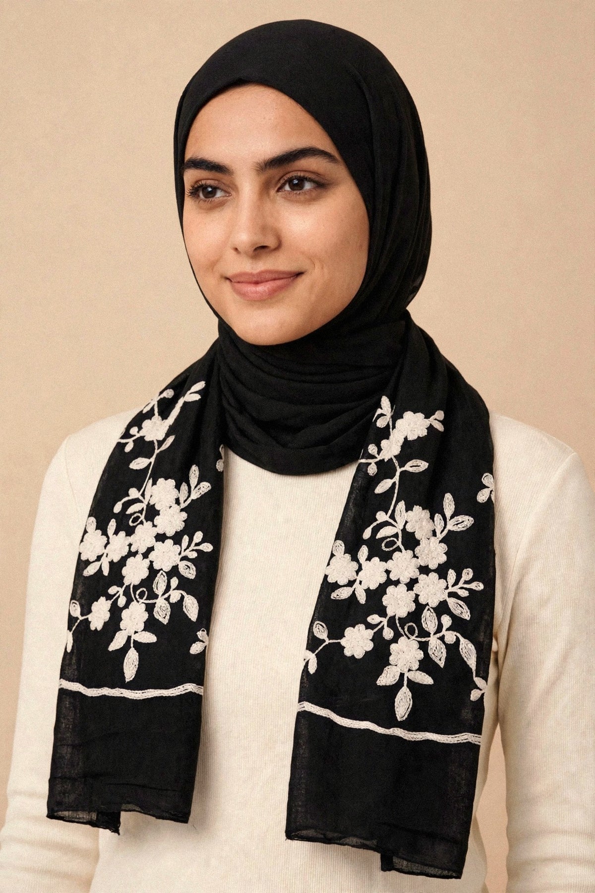 Model wearing the Wildflower hijab — black viscose with white floral embroidery on both ends